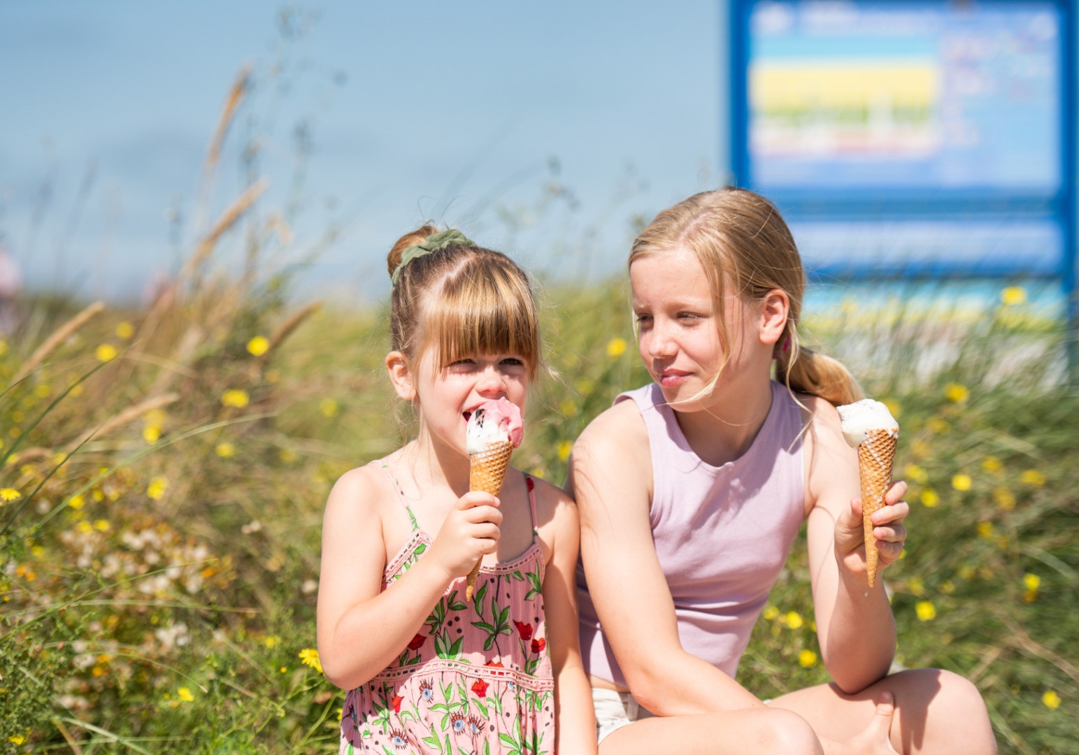 Twee meisjes eten een ijsje op de boulevard